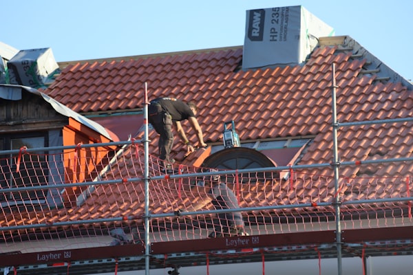 Roofer performing repair work on residential roof